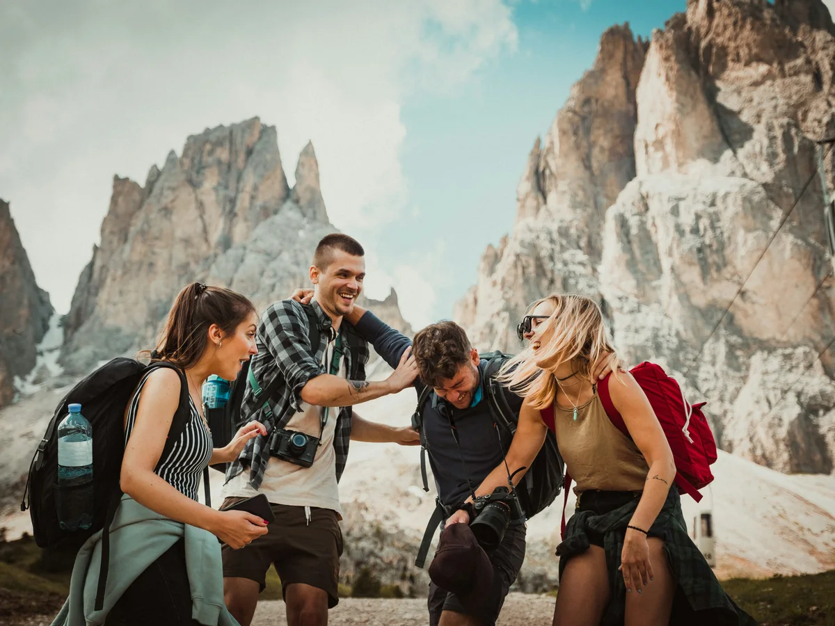 Illustrative mountain travel photo of four friends with backpacks